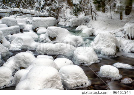 Long exposure of flowing cold frozen water in mountain stream Long exposure of flowing cold frozen water in mountain stream 96461544
