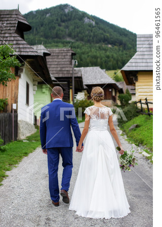 newlywed couple. bride and groom walking together away on the road 96461565