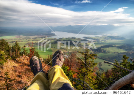 Legs of hiker with hiking boots on top of the hill with beautiful landscape under 96461642