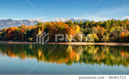 Autumn panoramic landcape with reflection of colorful trees in water and mountains at background. 96461715