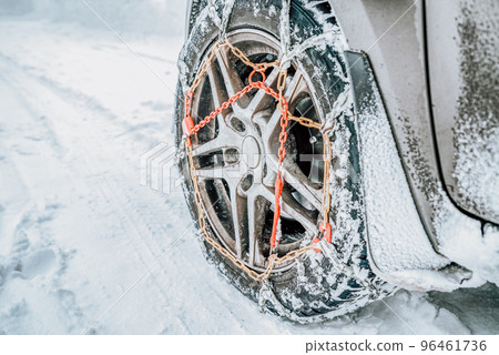 Snow chains on tire at winter road Snow chains on tire at winter road 96461736