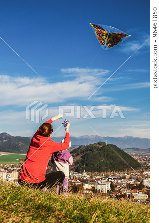 mother and daughter flying a kite together mother and daughter flying a kite together 96461850