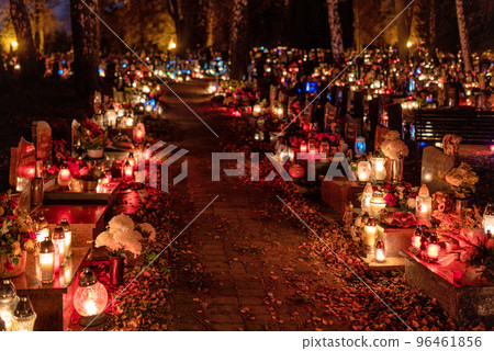 Candle lights on graves and tombstones in cemetery at night on All Souls Day 96461856