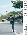 Young man traveller prepare his camera equipment ,standing on the walking street 96462159