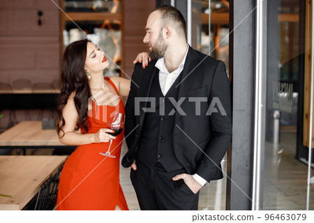 Romantic couple standing in restaurant on a date with glass of wine 96463079