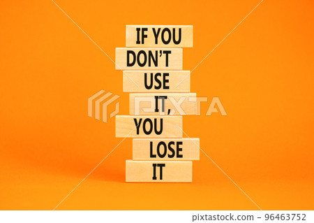 Use or lose symbol. Concept words If you do not use it you lose it on wooden blocks on a beautiful orange table orange background. Business motivational and use or lose concept. 96463752