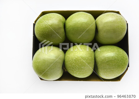 Six green apples on a cardboard backing on a white background. Delicious green apples close-up. 96463870