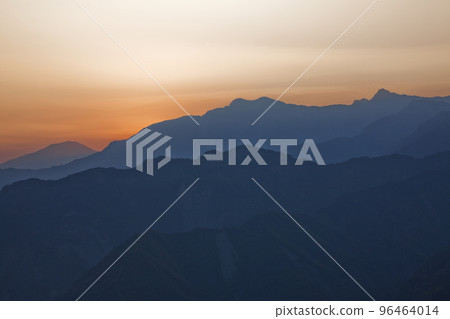Sunrise view of magnificent layered mountains and colorful clouds background. 96464014