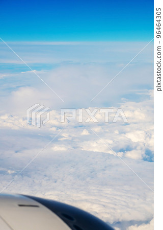 View from Boeing 737 MAX 8 on White Air Clouds And Clear Blue Sky. In frame White-Grey Engine Casing With Vanes. View from Boeing 737 MAX 8 on White Air Clouds And Clear Blue Sky. In frame White-Grey Engine Casing With Vanes. 96464305
