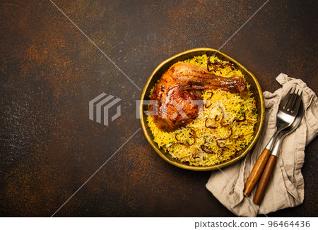 Indian dish Biryani chicken with basmati rice in metal brass old bowl on table Indian dish Biryani chicken with basmati rice in metal brass old bowl on table 96464436