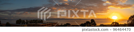 Panorama Of Sunrise From Corfu Island Overlooking Mountains Of Balkan Peninsula Of Greece, Moraitika, Corfu, Greece. In Foreground Are Hotel Buildings, Trees, Bungalow And Water Slide. Panorama Of Sunrise From Corfu Island Overlooking Mountains Of Balkan Peninsula Of Greece, Moraitika, Corfu, Greece. In Foreground Are Hotel Buildings, Trees, Bungalow And Water Slide. 96464470