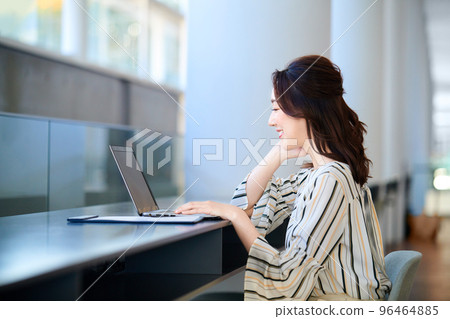 Business woman operating a personal computer at the counter in the office Business woman operating a personal computer at the counter in the office 96464885