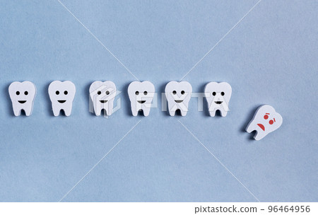 Tooth loss. Teeth row with fallen baby milk or adult one on blue background. Cavity, poor oral hygiene, gums inflammation, trauma. 96464956