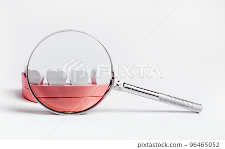 Jaw model with magnifying glass. Kids teeth checkup concept. Dental health problems diagnosis and caries and periodontal disease prevention. 96465052