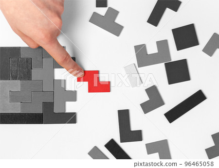 Hand putting outstanding puzzle piece. Logical thinking, problem solving concept. Important missing element adding. Uniqueness, standing out from crowd, individuality concept 96465058