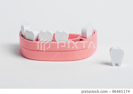Wooden jaw model and baby losing milk tooth. Primary, deciduous teeth loss. Oral hygiene, dental care concept. Children game at dentist Wooden jaw model and baby losing milk tooth. Primary, deciduous teeth loss. Oral hygiene, dental care concept. Children game at dentist 96465174