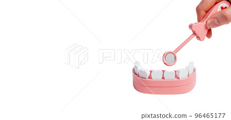 Banner with hand holding dental mirror for examining teeth and gums in jaw model isolated on white background. Children game at dentist. Oral hygiene concept. Copy space 96465177