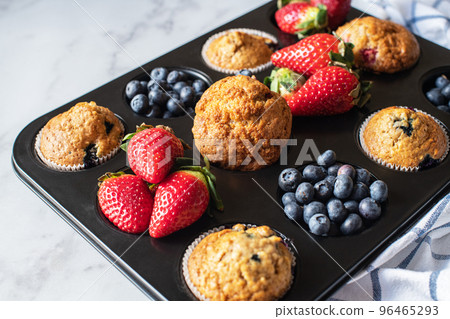 Assorted blueberry and strawberry muffins in a baking tin. Close up. Assorted blueberry and strawberry muffins in a baking tin. Close up. 96465293