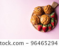 Strawberry muffins on a wooden board on a pink background. 96465294
