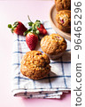 Strawberry muffins on a napkin on a pink background. Close up. 96465296