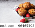 Strawberry muffins with berries served on a plate on a white marble background. 96465302
