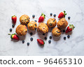 Blueberry and strawberry muffins on a white marble background. 96465310