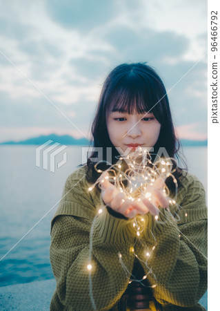 Photo of a young woman standing on the beach 96466792