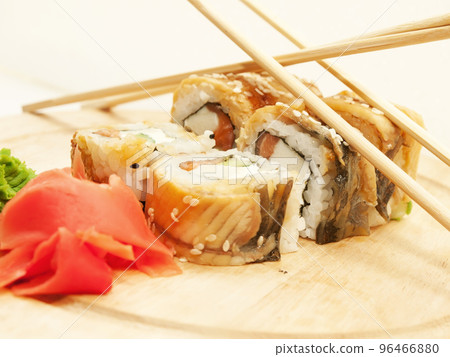 sushi rolls with omelette and eel and chopsticks on desk closeup sushi rolls with omelette and eel and chopsticks on desk closeup 96466880