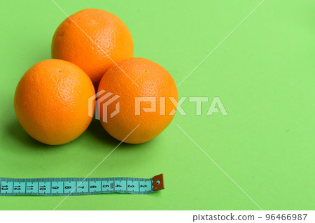 Pattern made of oranges near tape measure in cyan color 96466987