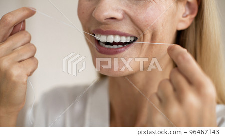 Toothcare and oral treatment concept. Closeup cropped view of unrecognizable middle aged woman using dental floss 96467143