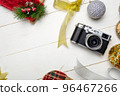 Flat lay festive composition with photo camera and colorful Christmas decorations on white wooden background with space for text 96467266