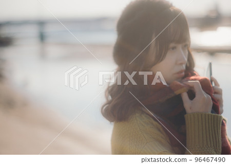 A photo of a young woman standing on the riverbed while listening to music A photo of a young woman standing on the riverbed while listening to music 96467490