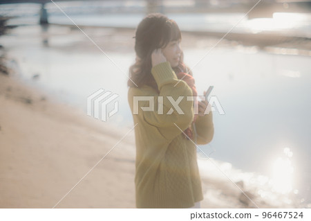 一位年輕女子站在河床上聽音樂的照片 一位年輕女子站在河床上聽音樂的照片 96467524