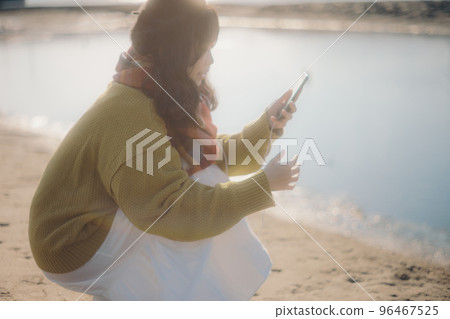 一位年輕女子站在河床上聽音樂的照片 一位年輕女子站在河床上聽音樂的照片 96467525