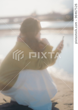 一位年輕女子站在河床上聽音樂的照片 一位年輕女子站在河床上聽音樂的照片 96467526