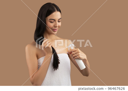 Beautiful long-haired adult woman using hair spray Beautiful long-haired adult woman using hair spray 96467626