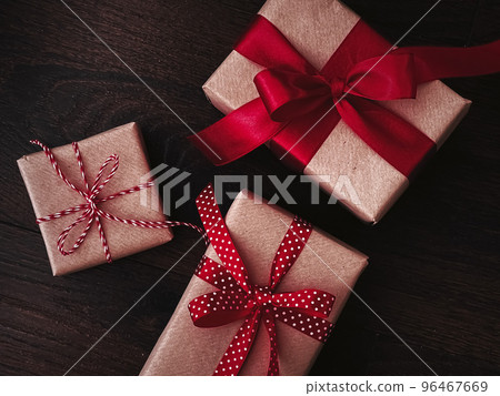 Christmas gifts and traditional holiday presents, classic xmas gift boxes on wooden background, present wrapped in craft paper with red ribbon, vintage rustic countryside style for seasonal holidays Christmas gifts and traditional holiday presents, classic xmas gift boxes on wooden background, present wrapped in craft paper with red ribbon, vintage rustic countryside style for seasonal holidays 96467669