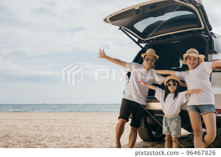 Happy Family Day. People enjoying road trip standing on back their car raise arms and hand up, Father, Mother and daughter traveling at sea beach, small family having fun in summer vacation on beach Happy Family Day. People enjoying road trip standing on back their car raise arms and hand up, Father, Mother and daughter traveling at sea beach, small family having fun in summer vacation on beach 96467826