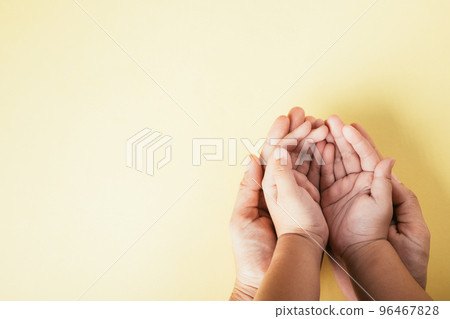 Closeup top view family hands stack palms studio shot isolated on yellow background, parents and kid holding empty free space on hand together, Gesture sign of support and love, Family and parents day Closeup top view family hands stack palms studio shot isolated on yellow background, parents and kid holding empty free space on hand together, Gesture sign of support and love, Family and parents day 96467828