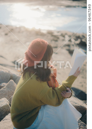 一位年輕女子站在河床上看書的照片 一位年輕女子站在河床上看書的照片 96467849