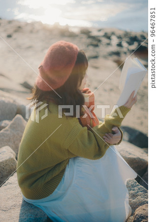 一位年輕女子站在河床上看書的照片 一位年輕女子站在河床上看書的照片 96467851