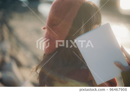 一位年輕女子站在河床上看書的照片 96467908