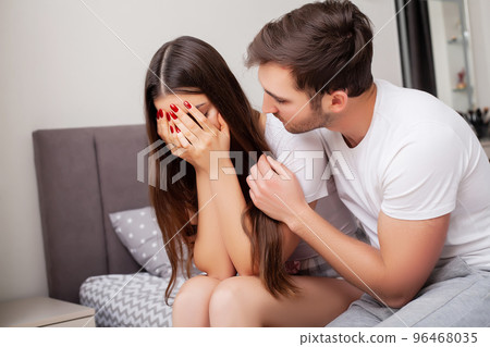 Happy sensual young couple lying in bed together Happy sensual young couple lying in bed together 96468035