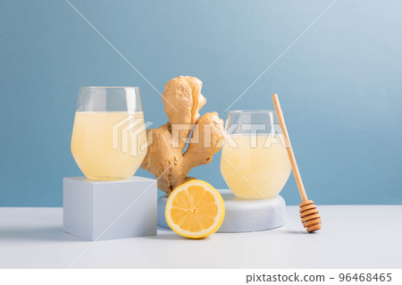 Antioxidant drink fresh ginger lemon in a glass trendy blue background, podium minimalism, balance 96468465