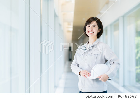 Female engineer holding a helmet 96468568