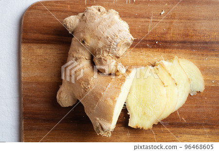 cutting fresh ginger spice at wooden desk. Healthy concept. flat lay cutting fresh ginger spice at wooden desk. Healthy concept. flat lay 96468605