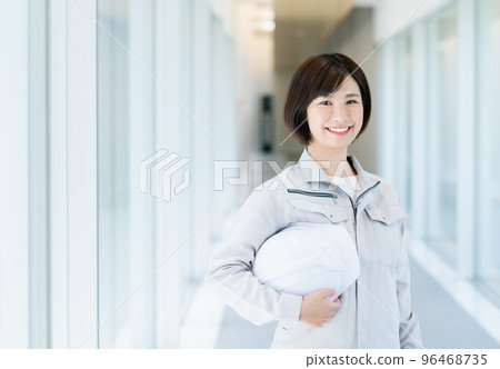 Female engineer holding a helmet 96468735