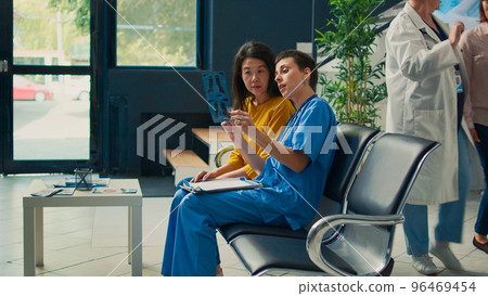 Nurse and asian patient analyzing x ray scan results at health center to find disease diagnosis. Looking at bones radiography and explaining orthopedic illness, checkup appointment. Nurse and asian patient analyzing x ray scan results at health center to find disease diagnosis. Looking at bones radiography and explaining orthopedic illness, checkup appointment. 96469454