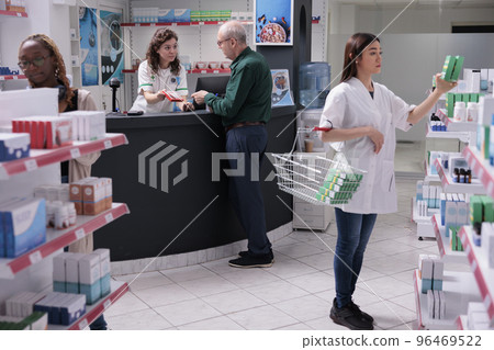 Elderly client talking with drugstore cashier asking for medical advice during medication shopping in pharmacy. Pharmacist recommending cardiology pills to prevent disease. Medicine concept Elderly client talking with drugstore cashier asking for medical advice during medication shopping in pharmacy. Pharmacist recommending cardiology pills to prevent disease. Medicine concept 96469522