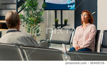 Asian woman waiting in facility lobby to attend medical appointment with specialist, doing checkup visit to receive prescription medicine and treatment. Senior person at hospital. 96469536